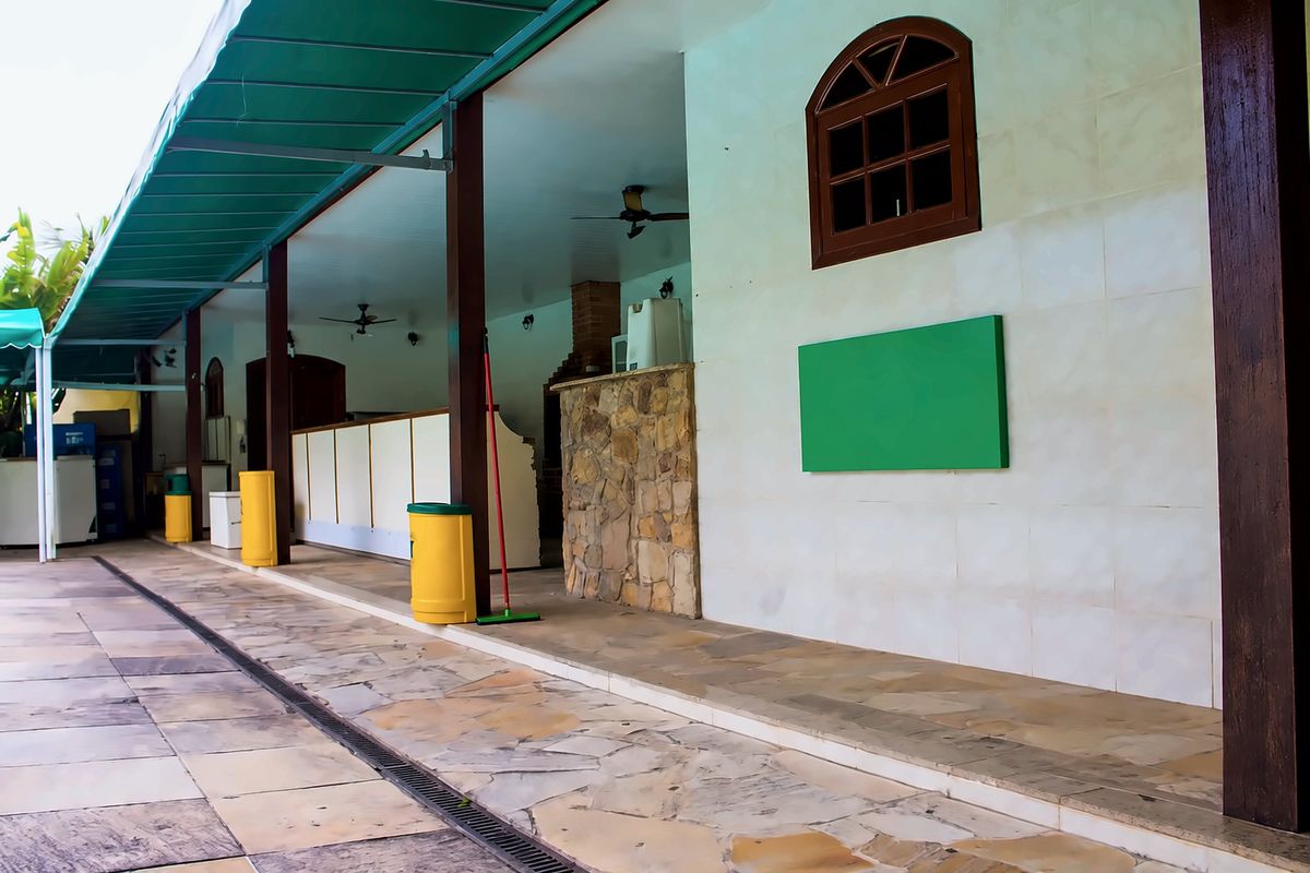 Varanda coberta com toldo verde e ventiladores de teto